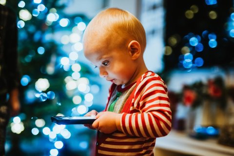 Kleinkind schaut auf Smartphonebildschirm 