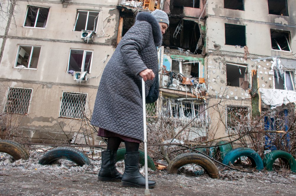 März 2022: Seniorin geht in der Nähe eines Wohnhauses, das nach Beschuss durch die russischen Besatzer in einem Wohngebiet von Charkiw zerstört wurde.